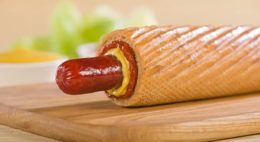 Pyszny hot dog francuski z musztardą i ketchupem, gotowy do zjedzenia.