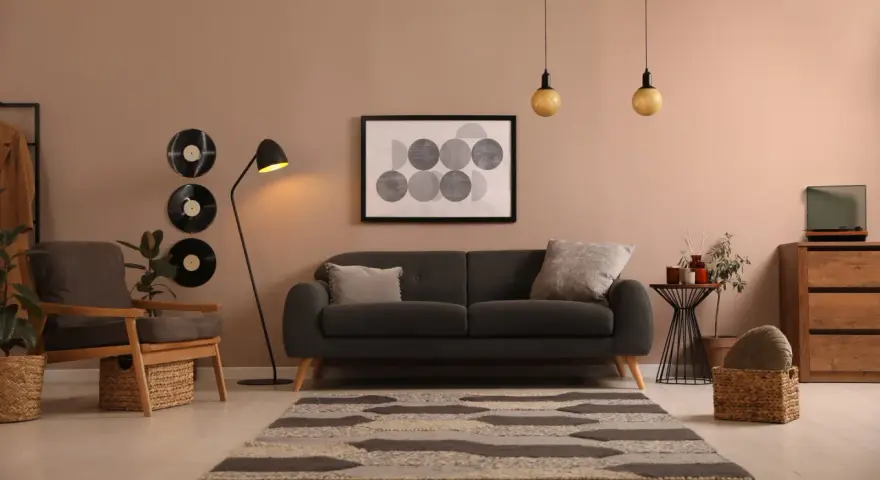 Idée déco salon avec canapé noir : ambiance cosy avec vinyles vintage, tapis graphique et fauteuil en bois.