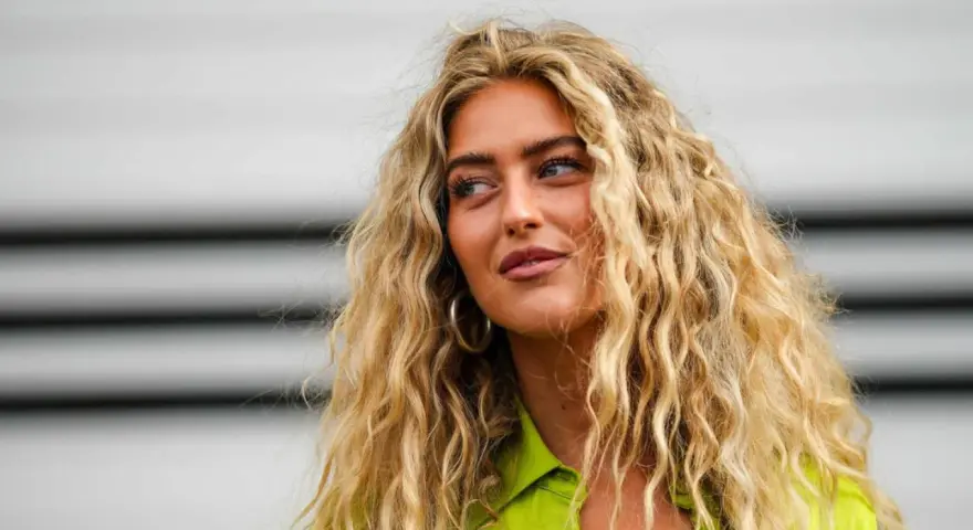 Frau mit voluminösen, blonden Locken, die zeigen, wie man Locken selber machen kann.