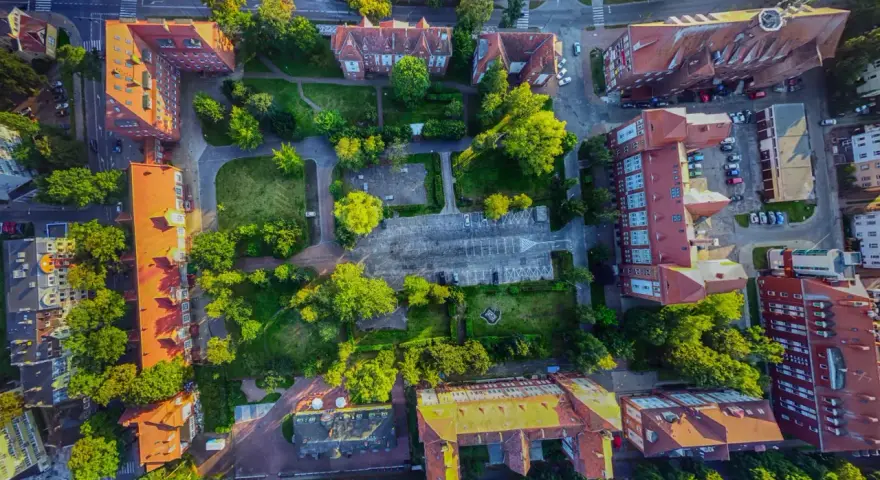 Widok z lotu ptaka na zabudowania i zieleń w Świnoujściu. Spacer po promenadzie i odkrywanie jej atrakcji z tej perspektywy to niezapomniane wrażenia.