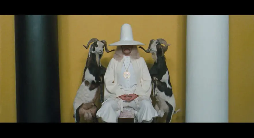 Uomo con cappello conico bianco e due capre imbalsamate, simbolo de la montagna sacra Jodorowsky.
