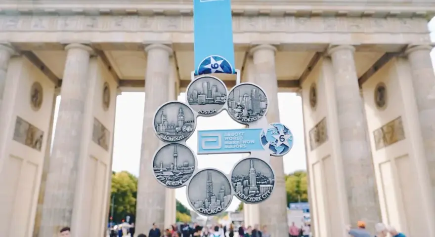 Medal za ukończenie korony maratonów świata z widokiem na Bramę Brandenburską.