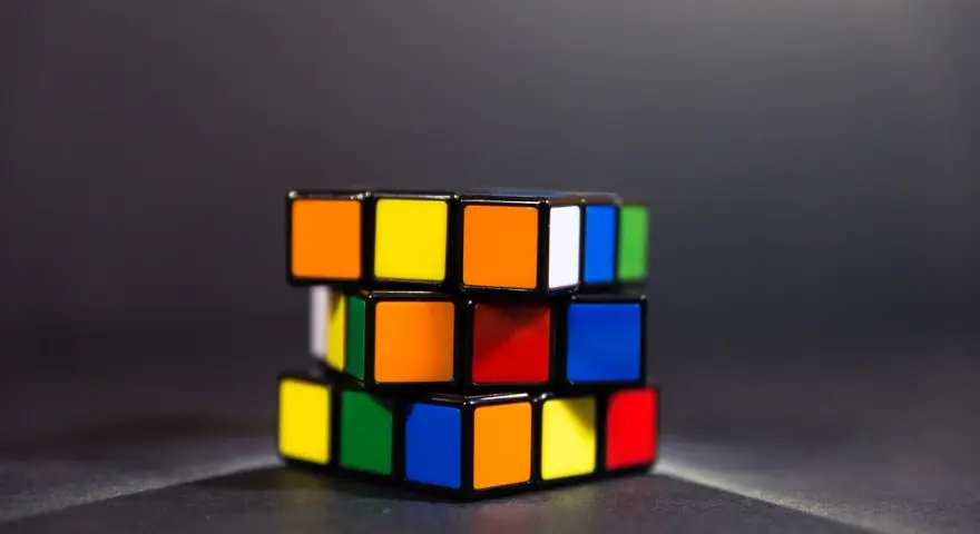 En färgglad speed cube ligger på ett mörkt underlag.