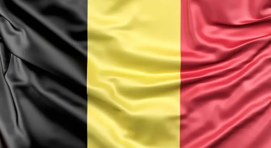 Falująca belgijska flaga z pionowymi pasami: czarnym, żółtym i czerwonym.