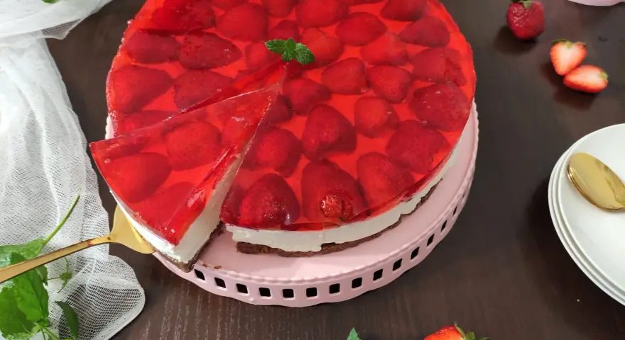 Najdelikatniejszy sernik z mascarpone na zimno, udekorowany truskawkami w galaretce. Idealny na letnie popołudnie.