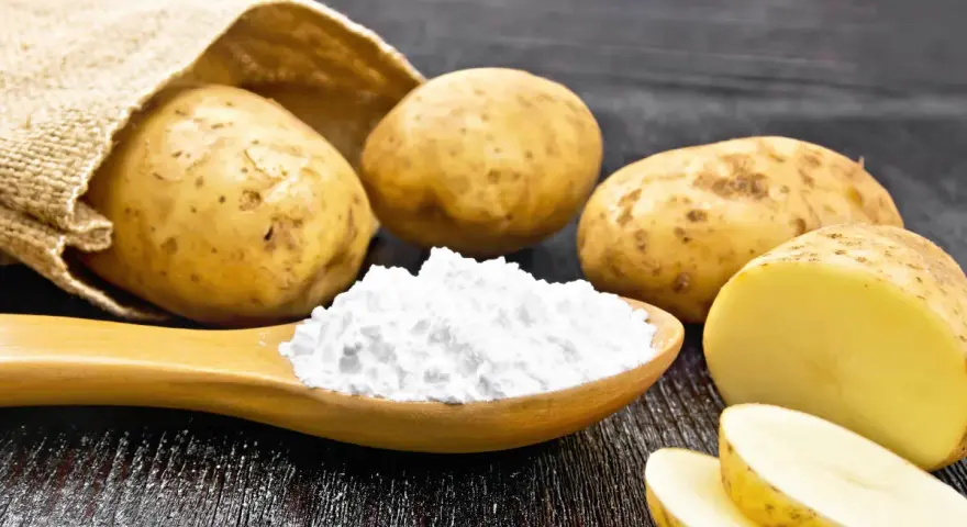 Kartoffeln und ein Löffel voller Kartoffelstärke, eine vielseitige kartoffelmehl alternative für Küche und Haushalt.