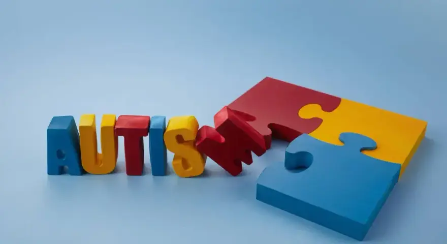 Kolorowe litery układają się w napis "AUTISM", obok fragmenty puzzli. Szukamy leków na autyzm dla dzieci, by pomóc im w rozwoju.
