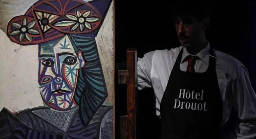 Portrait de Dora Maar par Picasso, présenté par un employé de l'Hôtel Drouot.