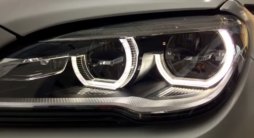 Nahaufnahme eines modernen Autoscheinwerfers mit leuchtendem Standlicht.