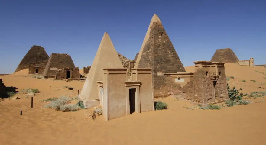 Niezwykłe piramidy w Meroe, fascynujące miejsca na sudan wycieczki. Piasek pustyni otacza starożytne budowle.