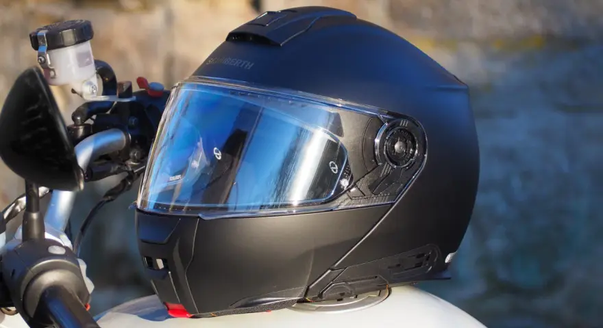 Casco Schuberth C5 negro con visera azul sobre una moto.