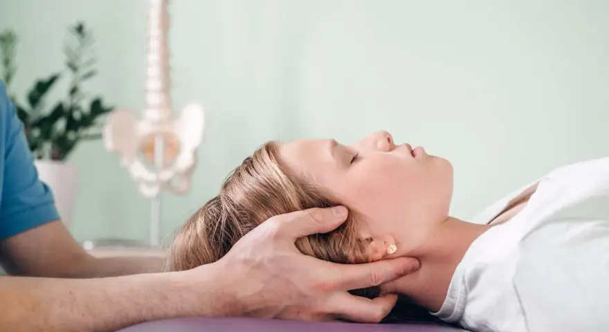Delikatna terapia krzyżowo czaszkowa dla ulgi w napięciu. Terapeuta delikatnie uciska głowę pacjentki.