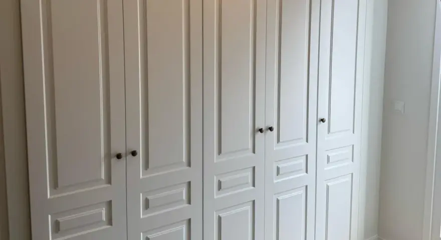 Armario empotrado blanco con puertas de paneles y tiradores oscuros. Perfecto para forrar armario empotrado y dar un toque elegante.