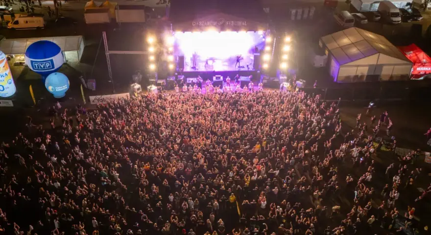 Tłum ludzi na koncercie podczas Cieszynów Rock Festiwal. Na scenie gra zespół, a przed nią tysiące fanów.