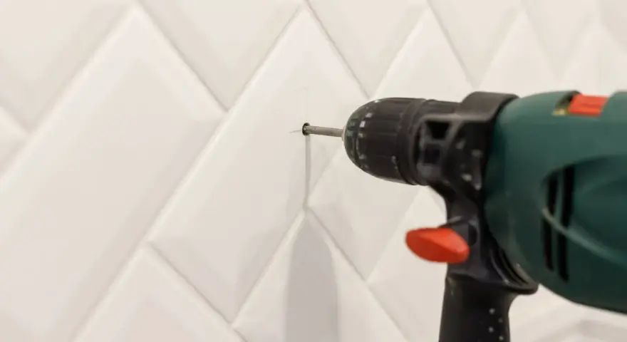 Une perceuse est utilisée pour percer le carrelage de la salle de bain.
