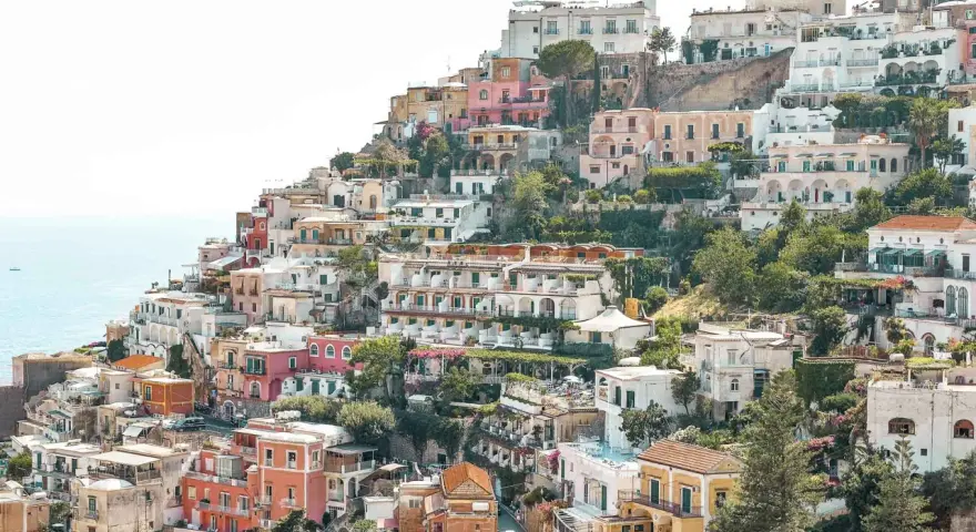 Colorful houses cascade down a hillside towards the sea, a picturesque scene perfect for any Europe itinerary.