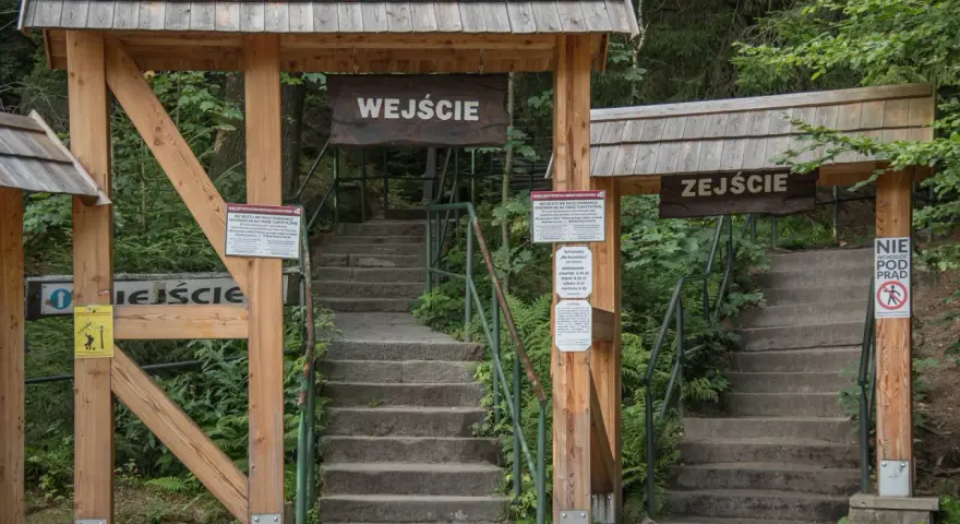 Kamienne schody prowadzące do wejścia na Szczeliniec Wielki. Informacje o biletach i cenniku dostępne są na tablicach.