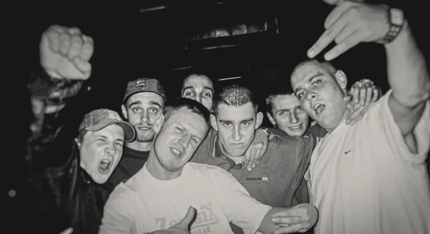 HZOP feat. Dudek RPK & RPS - każdy z nas. Grupa młodych mężczyzn pozuje do zdjęcia, jeden z nich pokazuje znak rock'n'rolla.
