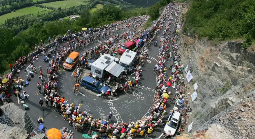 Spectators line the winding road of Alpe d'Huez for the Tour de France, a sea of color and anticipation.