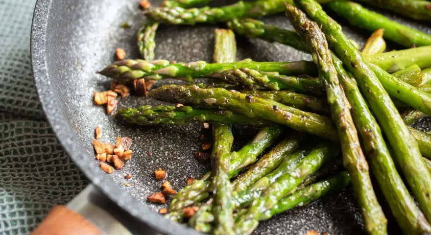 Asparagi in padella, croccanti e saporiti, con pezzetti di pancetta tostata che aggiungono un tocco in più.