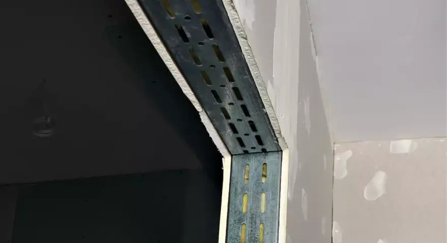 Metalowe profile wzmacniają konstrukcję w trakcie prac nad suchą zabudową. Widać fragmenty ścian z płyt gipsowo-kartonowych.
