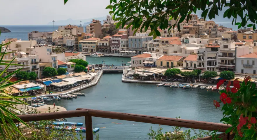 Malowniczy widok na port w Agios Nikolaos na Krecie. Woda lśni, a nadbrzeże tętni życiem.