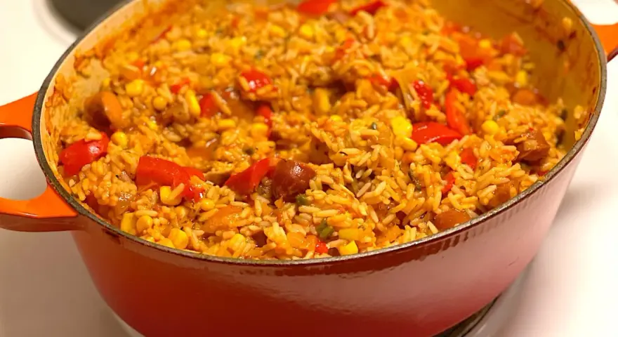 En orange gryta fylld med en smakrik jambalaya, full av ris, majs, paprika och korv. Ett perfekt recept för en mysig middag.