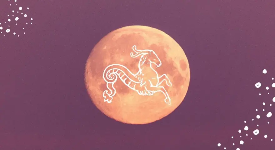 Pomarańczowy księżyc w Koziorożcu, ozdobiony białym symbolem zodiaku.