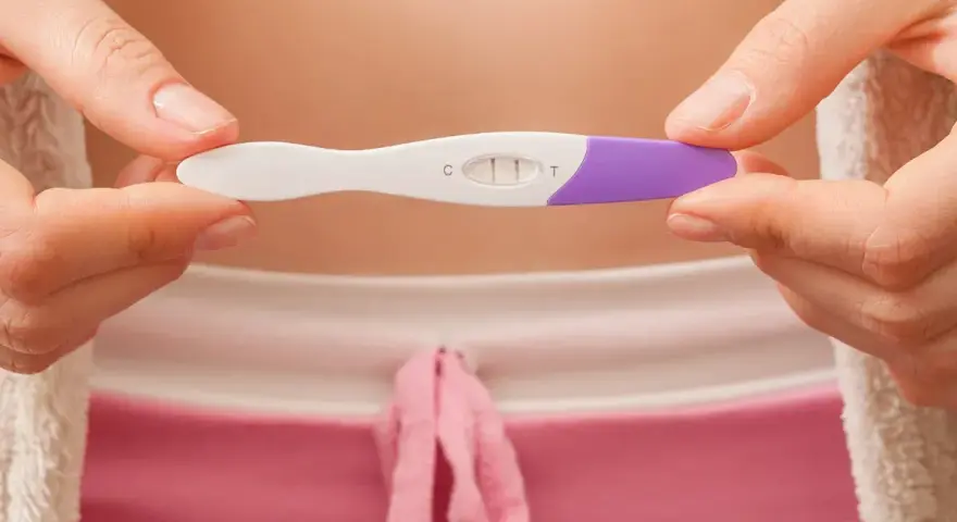 Dwie kreski na teście ciążowym pokazują, jak działa test ciążowy. Wynik pozytywny.