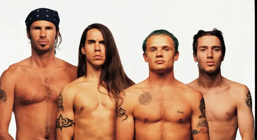Les membres des Red Hot Chili Peppers, torse nu, posent pour une photo. L'âge ne semble pas avoir d'emprise sur leur énergie.