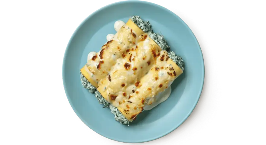 Tre cannelloni ripieni di ricotta e spinaci, gratinati al forno con besciamella e formaggio fuso, serviti su un piatto azzurro.