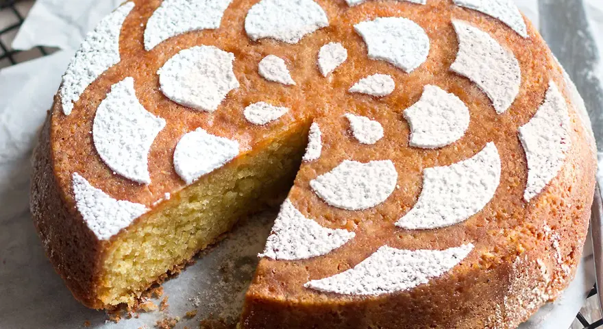 Deliziosa caprese al limone, soffice e profumata, con decorazione a fiore di zucchero a velo.