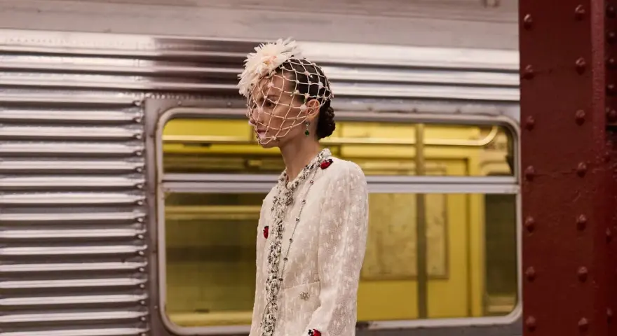Eleganza in stile coco chanel anni 20, con velo e perle, in attesa del treno.