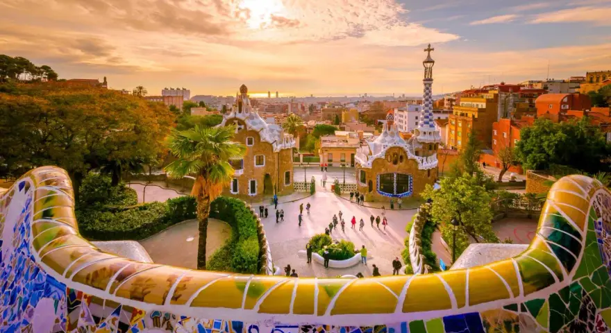 Kolorowy park Güell w Barcelonie, jednym z najpiękniejszych miast w Hiszpanii, zachwyca mozaikową ławką i bajkowymi budynkami.