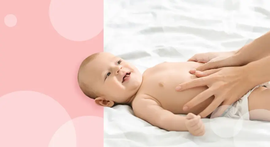 Uśmiechnięty noworodek się pręży i robi czerwony, gdy mama delikatnie masuje mu brzuszek.