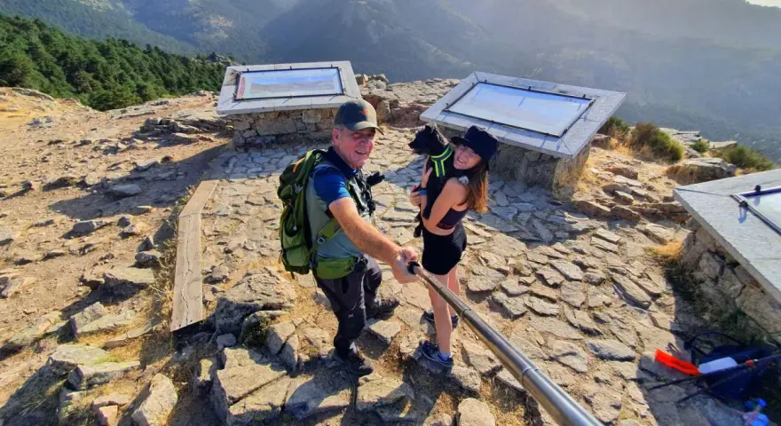 Pareja y perro posan en la barranca mirador de las canchas, disfrutando de las vistas montañosas.