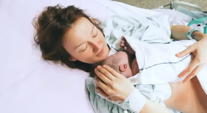 Mama tuli dziecko na rękach, szczęśliwa po 39 tygodniu ciąży.