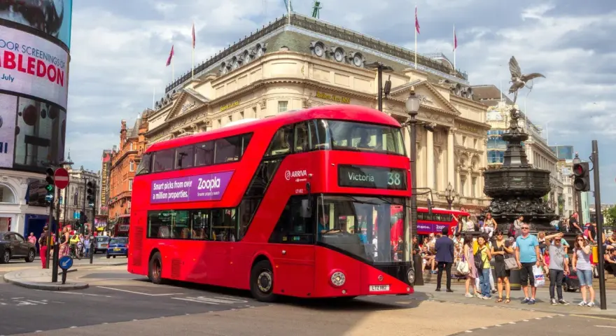 Czerwony piętrowy autobus w Londynie na tle Piccadilly Circus.