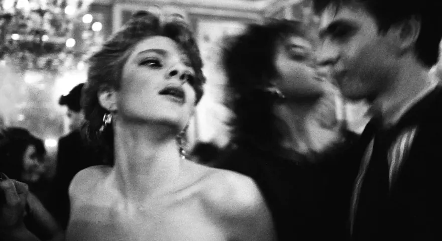 Letizia Battaglia uchwyciła moment intymności na balu. Kobieta w centrum, zmysłowo odwrócona, wpatrzona w nieznane.