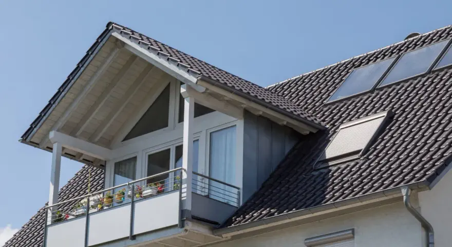Dachgaube mit Balkon und Solarpaneelen. Informieren Sie sich über Dachgaube Kosten für Ihr Zuhause.