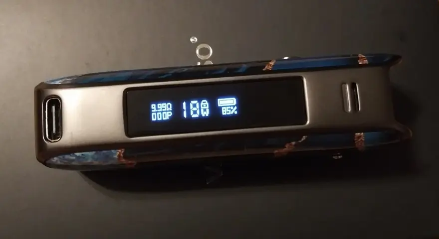 Vaporesso Luxe PM40 con pantalla mostrando 18W y 85% de batería. Diseño con detalles azules y marrones.