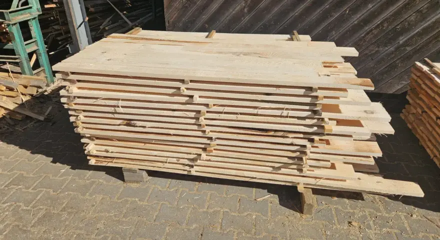 Stos desek z drewna sosnowego, gotowych do sprzedaży. Sprawdź aktualną drewno sosnowe cena za m3.