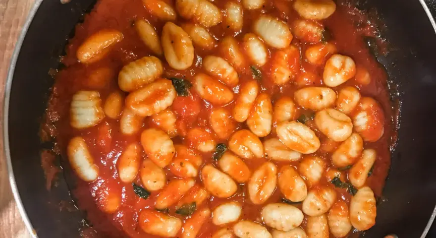 Pyszne gnocchi w aromatycznym sosie pomidorowym z ziołami, gotowe do podania. Idealny sos do gnocchi na szybki obiad.