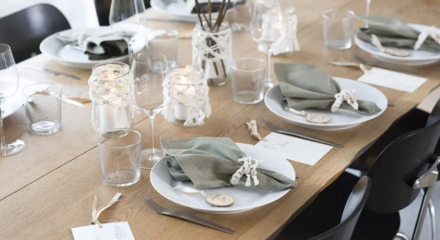Vacker dukning med gröna servetter, ljus och blommor. Perfekt fest dekoration inspiration för ett stilrent hem.