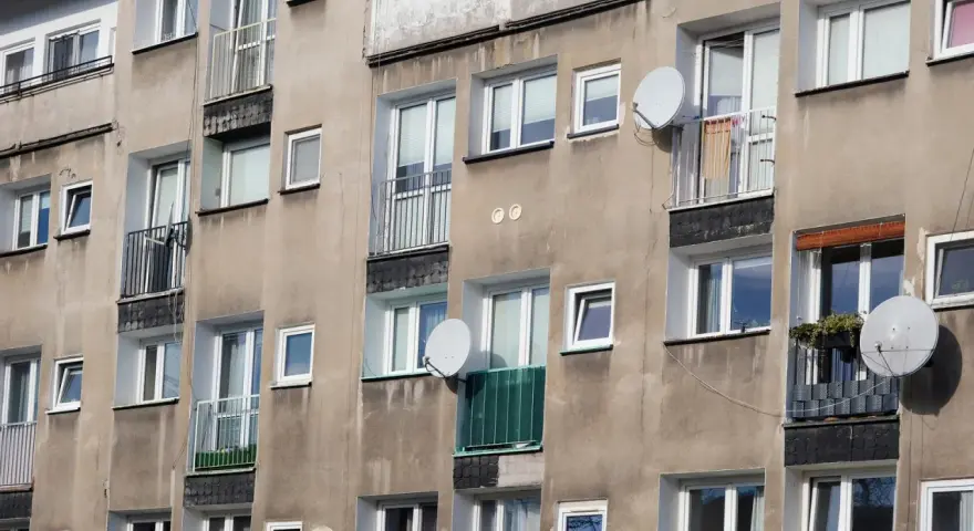 Szare bloki mieszkalne z balkonami i antenami satelitarnymi. Czy wojsko daje mieszkanie w takich budynkach?