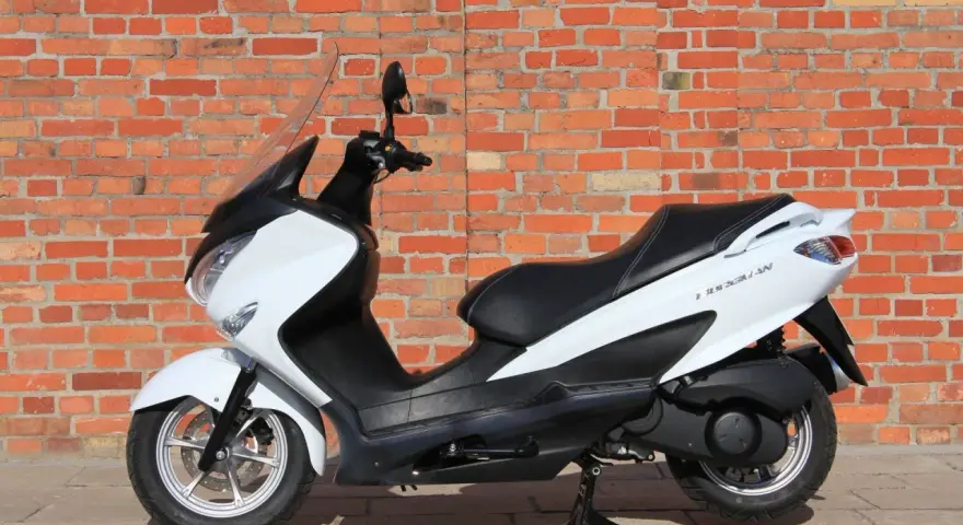 Biały skuter Suzuki Burgman 125, idealny do miasta, z niskim spalaniem.