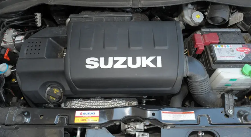 Silnik Suzuki Swift 2007 z widocznym logo SUZUKI na pokrywie. Widać akumulator i elementy układu dolotowego.