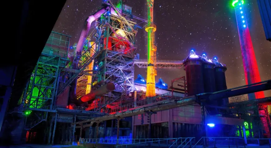 Industrielles Lichterspiel im Landschaftspark Duisburg unter sternklarem Himmel. Bunte Beleuchtung verwandelt die Stahlriesen in ein Kunstwerk.