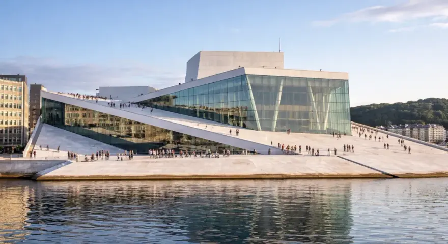 Oslo Operahus, en arkitektonisk pärla vid vattnet, liknar en isberg som reser sig ur fjorden. En populär plats för både turister och lokalbefolkning, likt de som besöker Oslo museer.