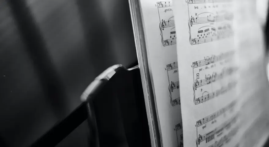 Spartito musicale aperto, con note e indicazioni di tempo, evoca le grandi colonne sonore che hanno segnato cinema e TV.